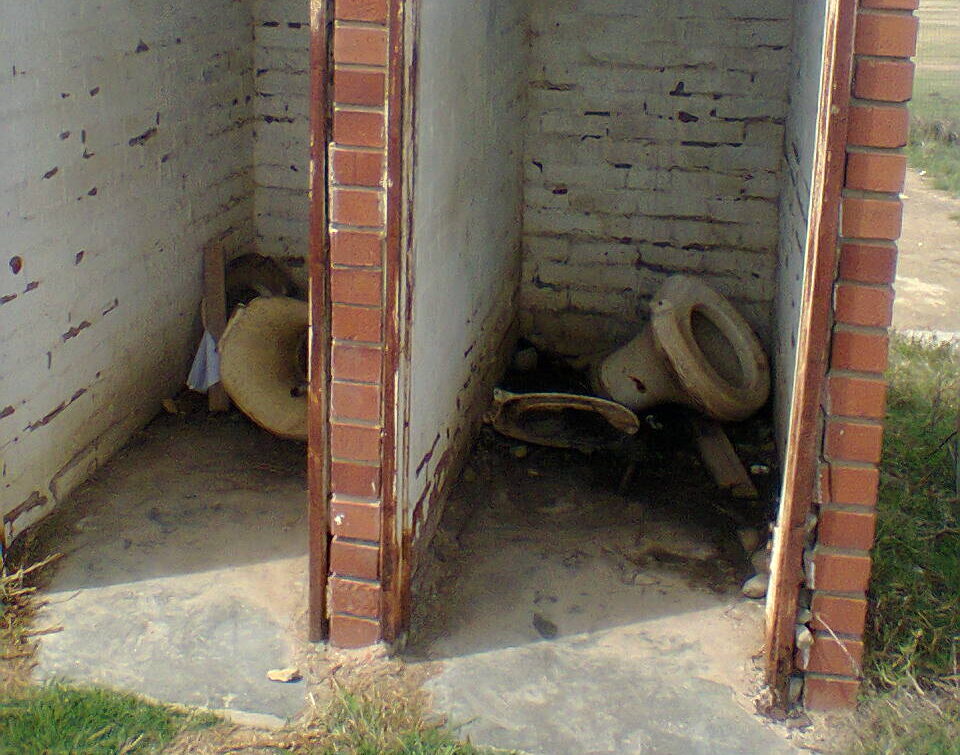 School sanitation facilities in Eastern Cape, South Africa in 2014. There are two cubicles with toilets collapsed in both.